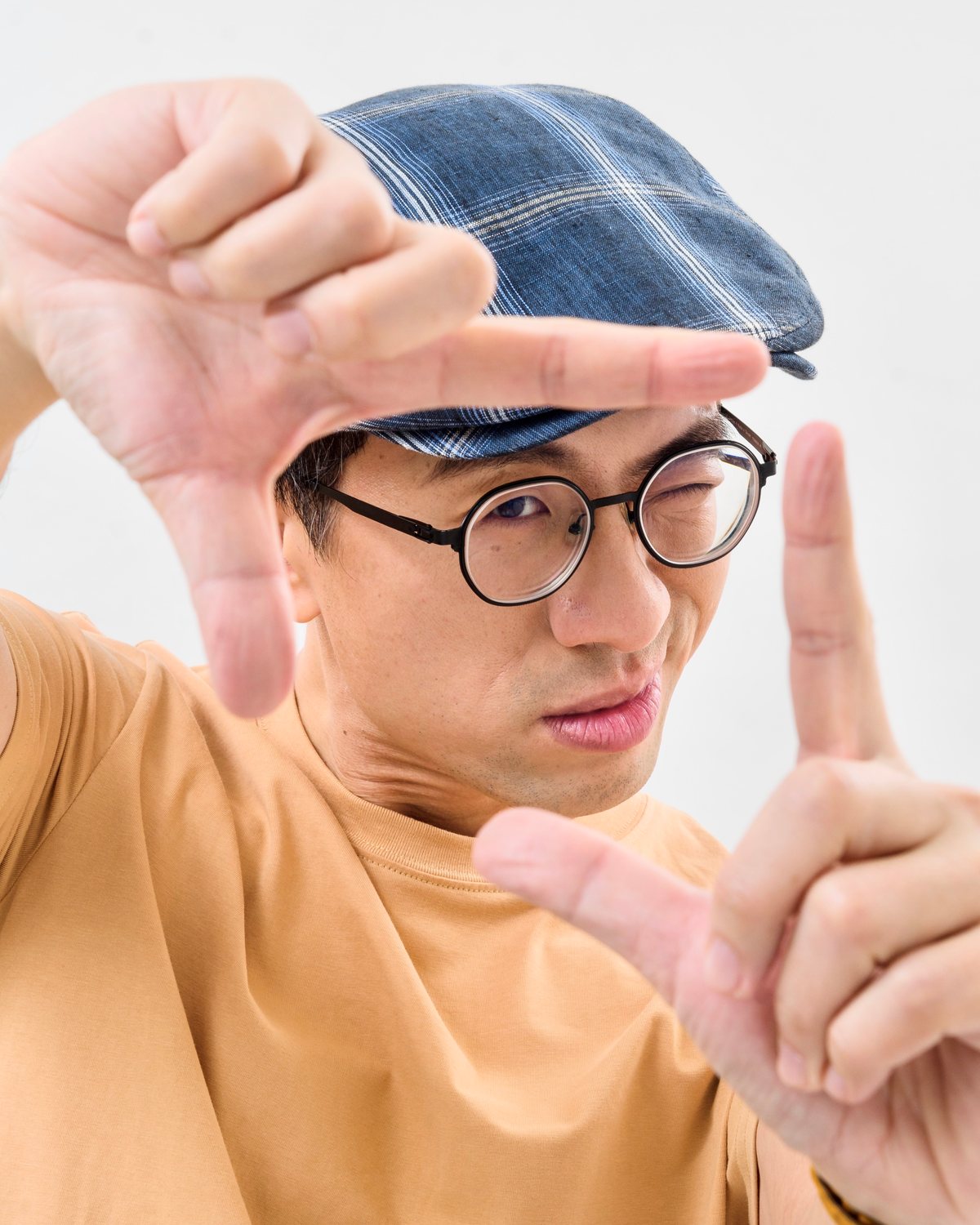 璁導用手指框出取景框，閉起一隻眼，透過手框直視鏡頭